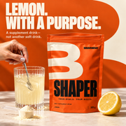 SHAPER lemon supplement drink mixed beside an opened 300 g pouch